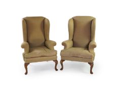 A pair of late 19th / early 20th century George II style upholstered wing armchairs with beige linen
