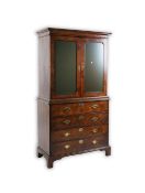 A George l feather banded walnut secretaire cabinet the mirrored upper section enclosing an