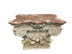 A marble topped white painted composition Ionic capital, now as an occasional table or stand. 76cm