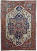 An early 20th century Heriz ivory ground carpet woven with a large central stepped floral