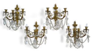 A set of four Louis XVI style ormolu and crystal wall sconces, the central fluted shaft surmounted