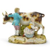 A Meissen group of a boy and girl milking a cow, 19th century, on a rococo scrollwork base,