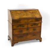 A George I feather banded walnut bureau, the fall enclosing a stepped interior with well over four