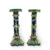 A pair of Continental majolica pedestals, late 19th century, each moulded with leaves and painted in