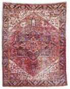 A Heriz brick red ground carpet with large central geometric medallion within a dense floral field
