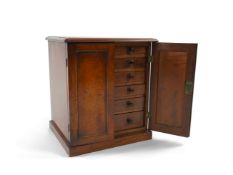 A George IV mahogany table top collectors cabinet, the pair of panelled cupboard doors enclosing two