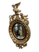 A Regency carved giltwood and composition convex wall mirror, with eagle surmount, width 54cm,