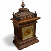 An early 20th century carved oak mantel clock, with key and pendulum, 58cm high
