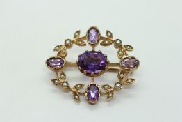 A 9CT GOLD AMETHYST AND SEED PEARL SET BROOCH.