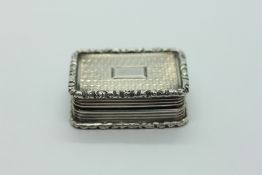 AN ANTIQUE SILVER VINAIGRETTE, ENGINE TURNED DESIGN WITH A GILT INTERIOR,