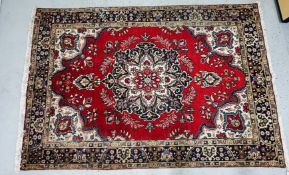 A LARGE EASTERN CARPET, THE CENTRAL MEDALLION ON A RED GROUND 200 X 290CM.