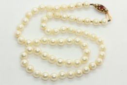 A VINTAGE SINGLE STRAND PEARL NECKLACE OF UNIFORM STONES WITH A 9CT GOLD GARNET AND PEARL CLASP (L