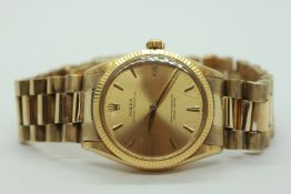 A GENTLEMAN'S ROLEX OYSTER PERPETUAL 9CT GOLD CASED WRIST WATCH MODEL 1005 ON YELLOW METAL BRACELET