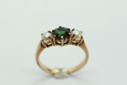 A TOURMALINE AND PEARL 9CT GOLD DRESS RING, THE CENTRAL STONE FLANKED BY TWO PEARLS.