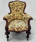 A VICTORIAN SHAPED BACK EASY CHAIR WITH BUTTON BACK FLORAL UPHOLSTERY.