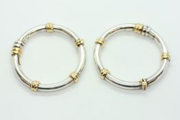 A PAIR OF DESIGNER TWO TONE SILVER HOOP EARRINGS.
