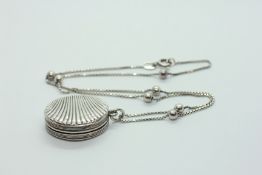 AN ANTIQUE SILVER PENDANT VINAIGRETTE SHELL DESIGN WITH A GILT INTERIOR SUSPENDED ON A SILVER BALL