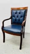 A REPRODUCTION STUD AND BUTTON BACK ARMCHAIR UPHOLSTERED IN A NAVY BLUE LEATHER, WITH CARVED ARMS.