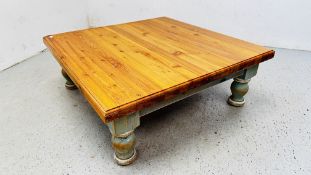 A LARGE TWO DRAWER HONEY PINE LOW COFFEE TABLE ON 4 TURNED PAINTED SUPPORTS 115 X 115 X H 42CM.