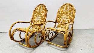 A PAIR OF BAMBOO FRAMED ROCKING CHAIRS ALONG WITH A GLASS TOP BAMBOO FRAMED COFFEE TABLE.