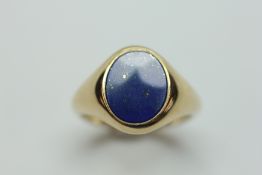 A LAPIS LAZULI SIGNET RING ON A 9CT GOLD BAND.