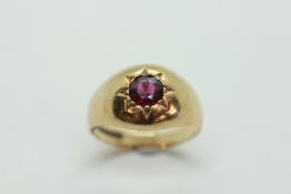 A 9CT GOLD BAND RING WITH AMETHYST IN STARBURST RUB OVER SETTING.
