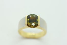AN UNMARKED BAND RING, THE OVAL GREEN GEM STONE IN A CUPPED SETTING.