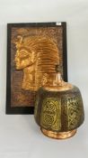 A COPPER EMBOSSED EGYPTIAN PLAQUE ALONG WITH A COPPER FINISH AND ETHNIC DESIGN TABLE LAMP - SOLD AS
