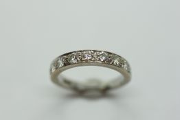 A DIAMOND HALF ETERNITY RING, THE NINE STONES CLAW SET ON AN 18CT WHITE GOLD BAND.
