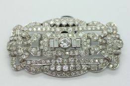 AN EARLY C20th DIAMOND BROOCH OF STRAPWORK DESIGN, THE CENTRAL CIRCULAR STONE APPROXIMATELY 6MM,