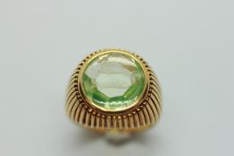 AN 18CT GOLD RING, THE PALE GREEN STONE ENGRAVED WITH TWO FISH.