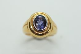 AN 18CT GOLD DRESS RING TANZANITE RING IN BEZEL SETTING.