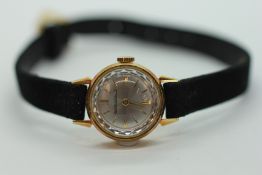 A LADY'S JAEGER LE COUTRE 18CT GOLD COCKTAIL WATCH ON A BLACK LEATHER STRAP WITH JAEGER LE COUTRE