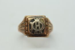 A 9CT GOLD GENT'S SIGNET RING BEARING A MONOGRAM.