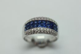A SAPPHIRE AND DIAMOND RING SET WITH TWO ROWS OF TEN SQUARE CUT SAPPHIRES BETWEEN SINGLE ROWS OF
