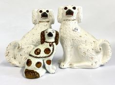 A PAIR OF STAFFORDSHIRE SPANIELS PLUS ONE OTHER.