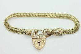 A WOVEN YELLOW METAL BRACELET, THE EMBOSSED MOUNT DEPICTING A FOX,