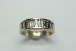 AN 18CT WHITE GOLD AND DIAMOND RING, SET WITH ELEVEN GRADUATED BAGUETTE CUT DIAMONDS.