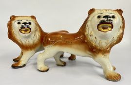 A PAIR OF VINTAGE STAFFORDSHIRE LION STUDIES L 35CM.
