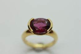 AN AMETHYST RING, THE OVAL STONE IN A DOUBLE CRESCENT SETTING, ON AN 18CT GOLD BAND.