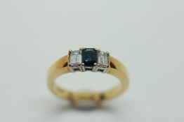 A SAPPHIRE AND DIAMOND RING, THE CENTRAL BAGUETTE CUT STONE BETWEEN TWO BAGUETTE CUT DIAMONDS,