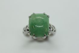 A JADE RING, THE RECTANGULAR STONE CLAW SET ON A SILVER BAND.
