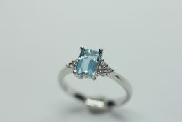 AN AQUAMARINE RING, THE BAGUETTE CUT STONE FLANKED BY SIX DIAMONDS.