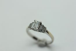 A DIAMOND TRIO RING, THE CENTRAL BAGUETTE CUT STONE BETWEEN FOUR SMALLER BAGUETTES,