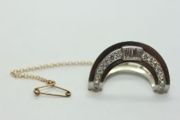 AN UNMARKED WHITE METAL DECO CRESCENT DESIGN CLIP ON BROOCH WITH SAFETY CHAIN SET WITH EIGHTEEN