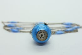 A GOUACHE ENAMEL WATCH ON CHAIN OF SPHERICAL FORM SET IN WHITE METAL.