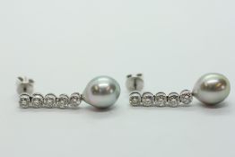 A PAIR OF WHITE METAL DIAMOND SET DROP EARRINGS (THE BUTTERFLIES MARKED 750),
