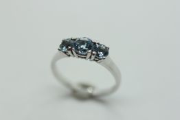 AN AQUAMARINE THREE STONE RING ON A 9CT GOLD BAND.