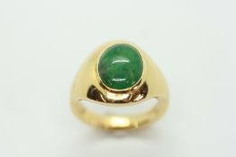 AN 18CT YELLOW GOLD RING SET WITH OVAL JADE CABACHON.