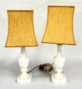 A PAIR OF POLISHED HARDSTONE TABLE LAMPS WITH MUSTARD SHADES - SOLD AS SEEN.